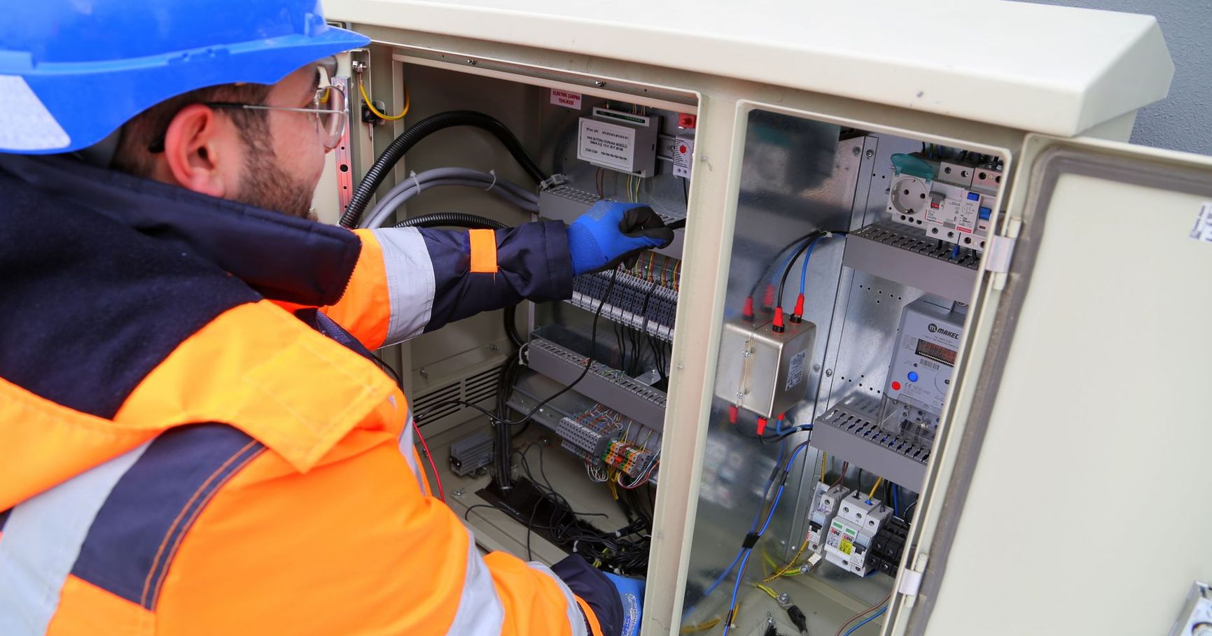 Local SEO for electricians: electrician working on an outdoor electrical panel